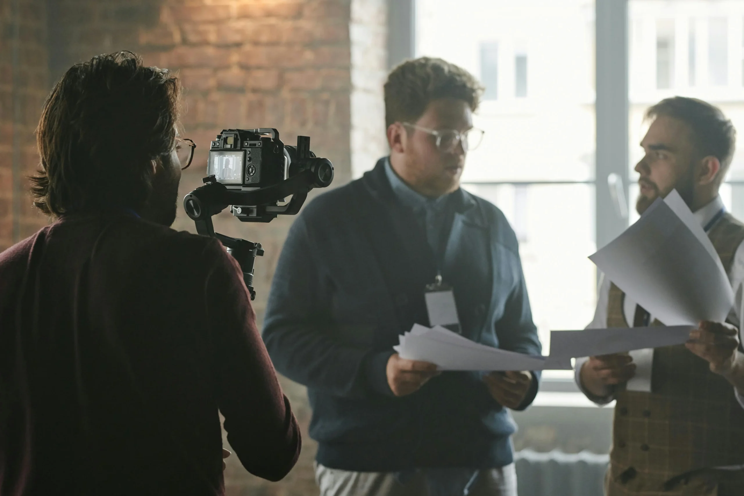 Filmmakers discussing script in studio.